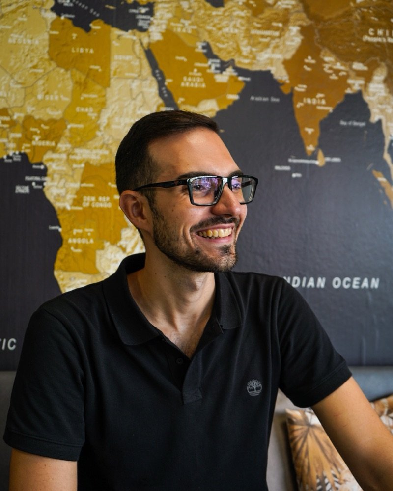 Jonathan Cataneo davanti a una mappa del mondo